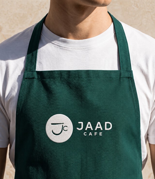 Barista Jaad Cafe mengenakan apron berlogo